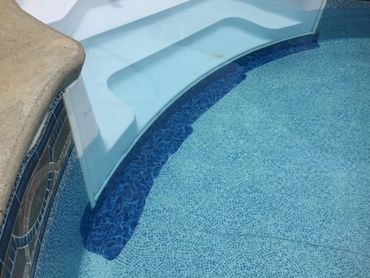 Patches on a swimming pool liner right next to the stairs.