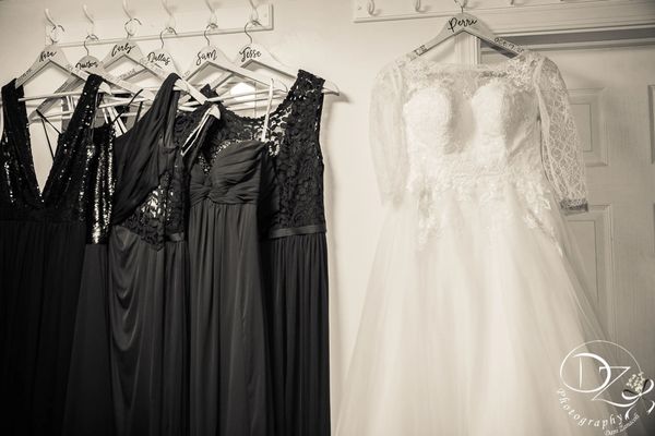 Wedding dress and bridesmaids dresses hanging on the wall.