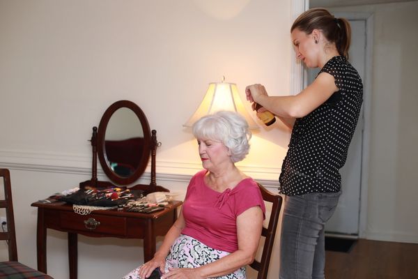 The mother of the bride getting ready for the wedding in the dressing room at our barn wedding venue.
