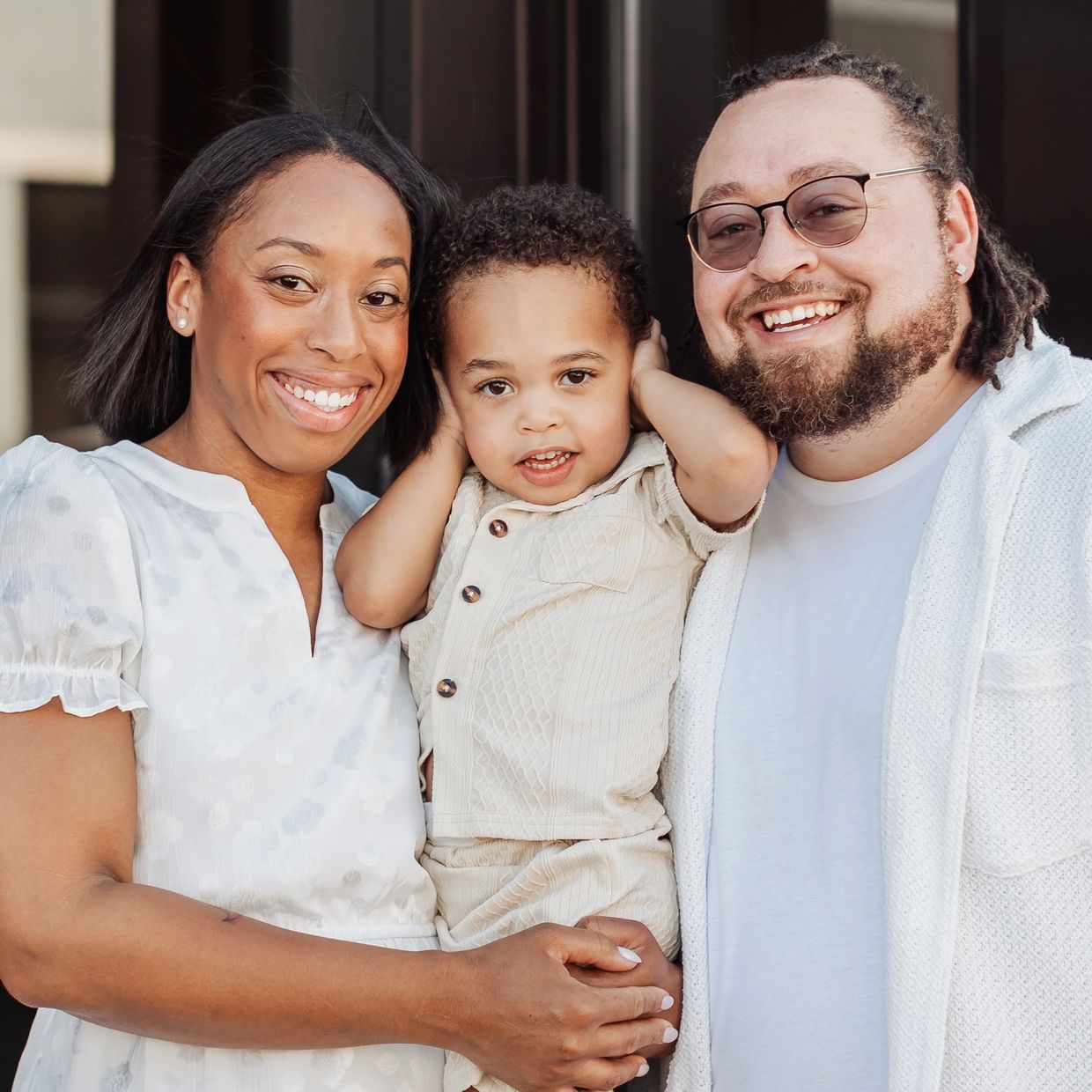 Happy family smiling together with their young child.