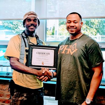 two men standing next to each other holding a certificate