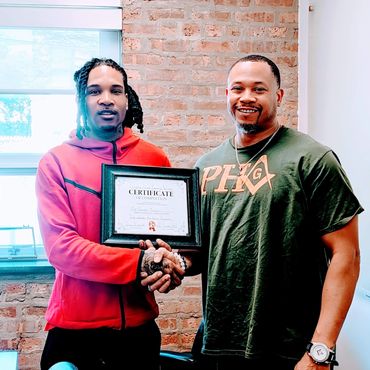 two men standing next to each other holding a certificate