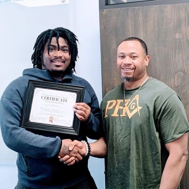 two men standing next to each other holding a certificate