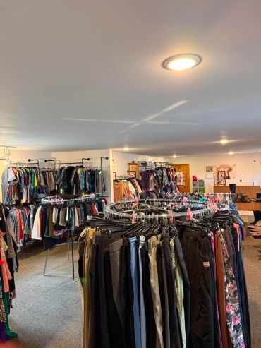 Interior of a clothing store with racks full of various clothes.