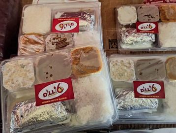Four packaged meals labeled 'Dilli 6' with rice and various dishes.