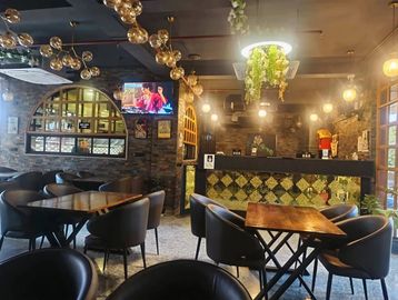 Cozy cafe interior with modern lighting and wooden tables.