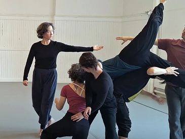 A group of ensemble dancers all connected