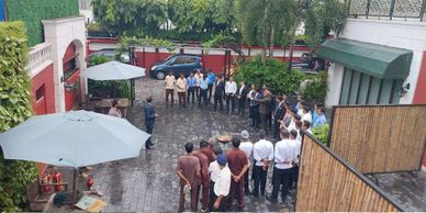 A group of professionals gathered outside for a meeting or briefing.