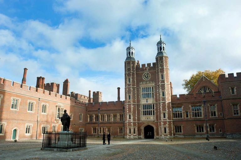 Historical brick building with clock tower and courtyard.