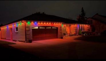 House decorated with colorful lights glowing warmly at night.