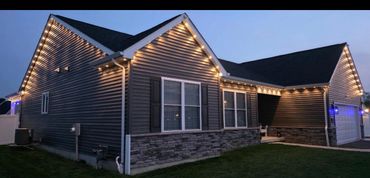 Modern house decorated with warm string lights in the evening.