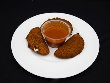 Two breaded cheese sticks with marinara sauce on a white plate.
