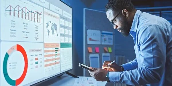Man analyzing data on a large screen.