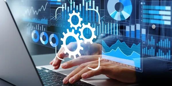 Person working on laptop with digital data charts and gears.