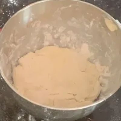 Dough mixture in a metal bowl on a countertop.