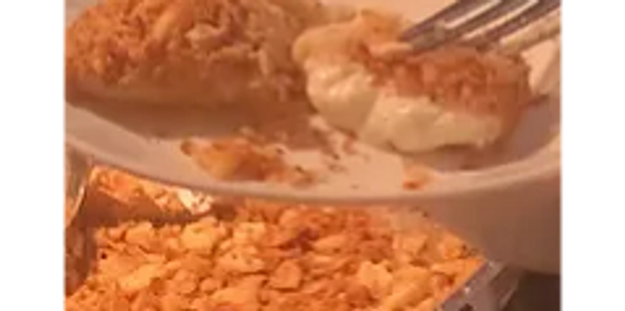 Cream-filled crispy snack being held with a fork on a plate.