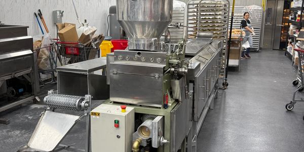 Industrial food processing machine in a spacious kitchen.