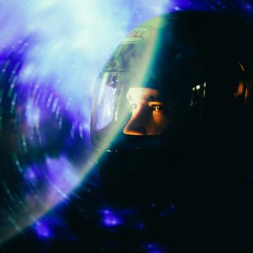 A F1 driver with a helmet on looking into the light