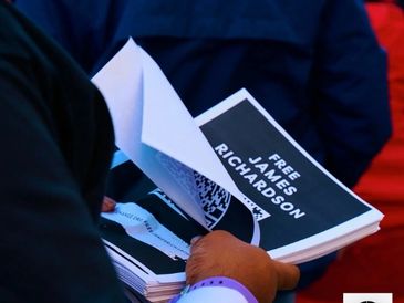 Person holds flyers demanding freedom for James Richardson.