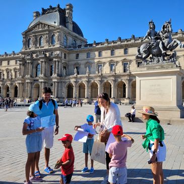 Louvre guide giving booklets to little kids in Louvre Carroussel court during a Louvre Treasure Hunt