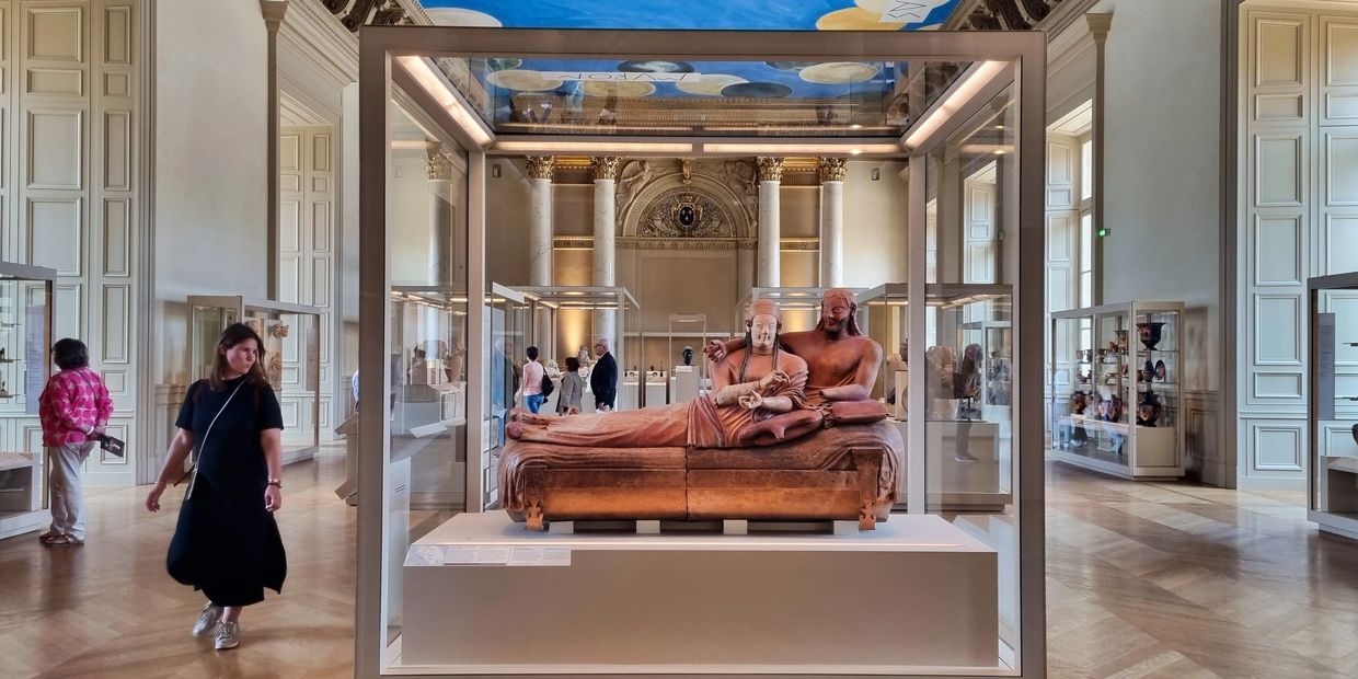 Flora walking next to the Etruscan sarcophagus of the spouses in the Louvre