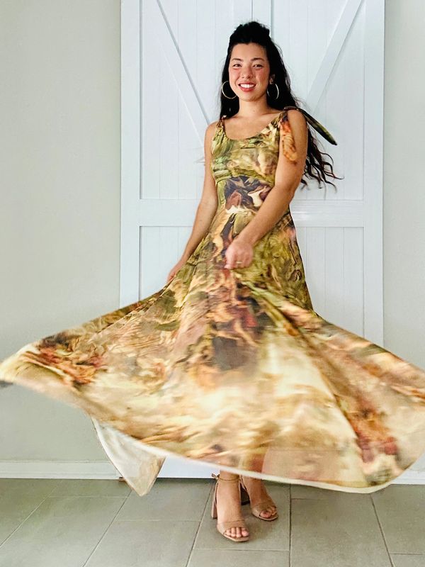 Woman twirling in a flowing, patterned dress with a bright smile.