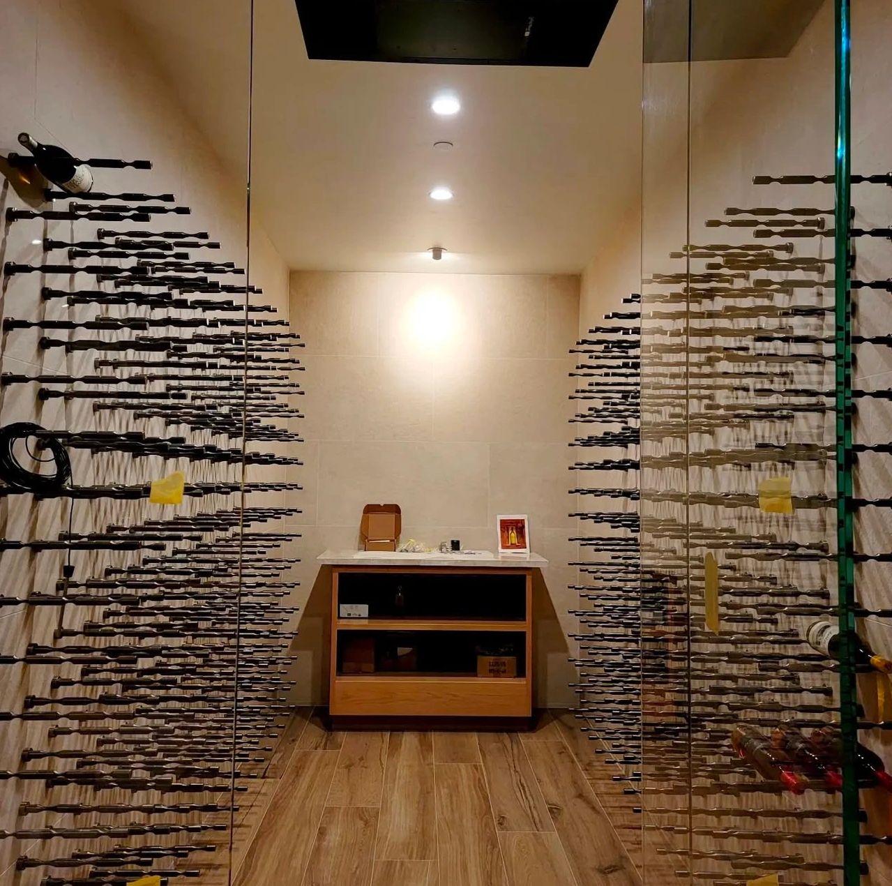 Modern wine cellar with sleek wall-mounted racks and wooden flooring.