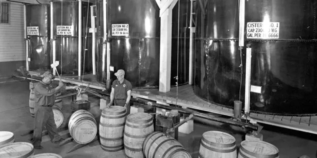 Historic black and white image of bourbon barrels. 