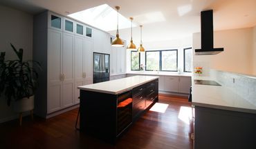 Modern kitchen with skylights, pendants and rangehood