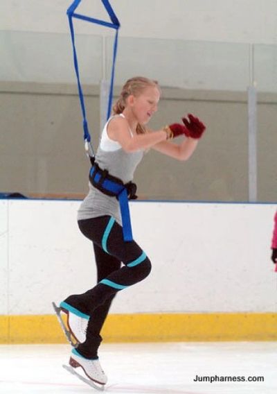 Young figure skater using jump harness training system at an ice rink in Madison, Wisconsin.