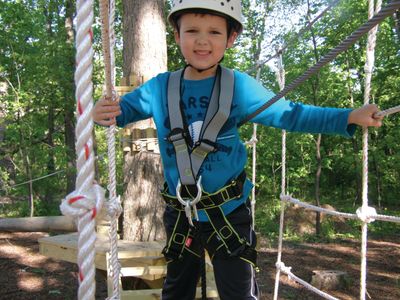Young boy on Kid's ropes course at an aerial adventure park in Northwest Indiana.