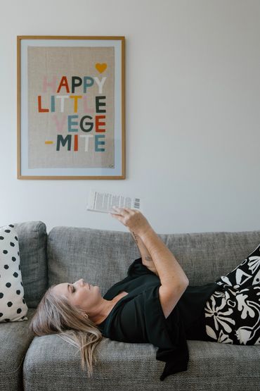 Karla McCullum laying down reading a book. Photography by THESE ARE THE DAYS PHOTOGRAPHY.