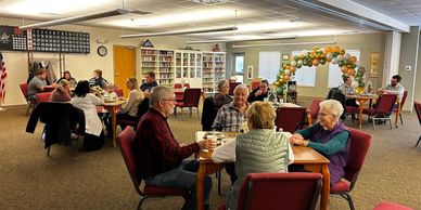 A group of people celebrating a birthday in the dining hall