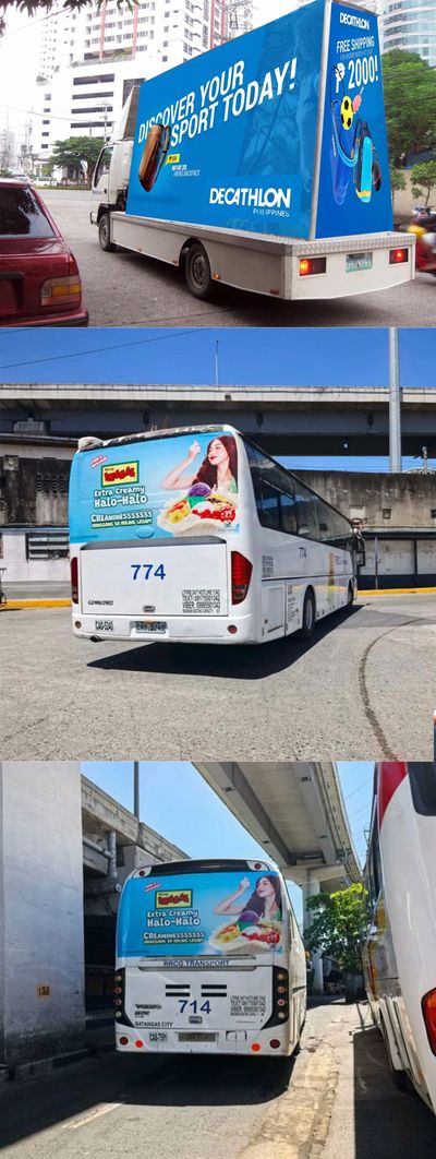 Advertising trucks and buses with vibrant promotional graphics in an urban area.