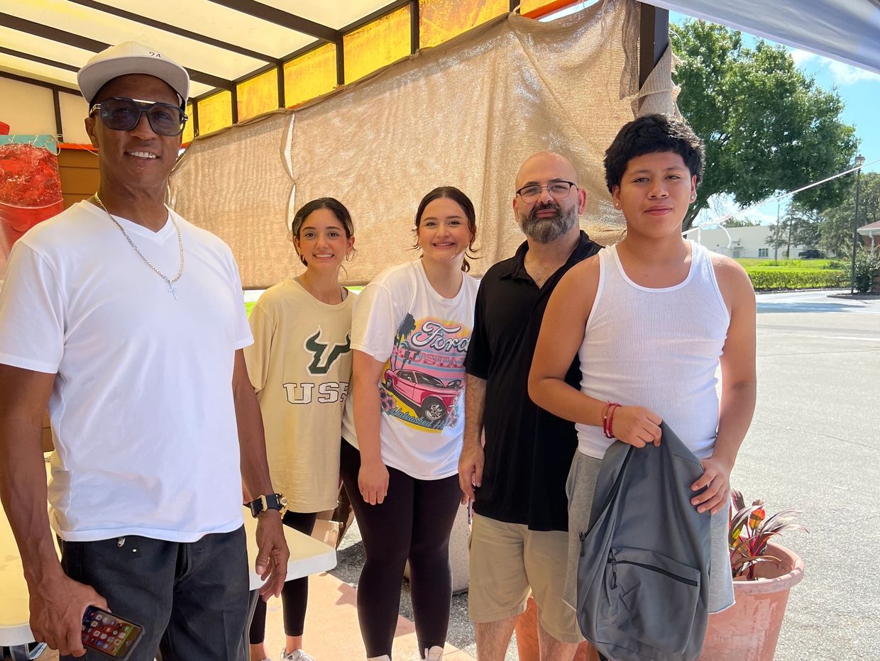 Founder - Billy Shannon - alongside community members giving backpacks and supplies to students.