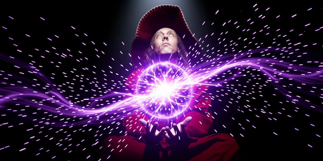 A person in a red outfit conjuring a glowing purple energy orb.