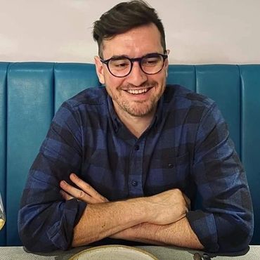 Sam sat in a restaurant smiling