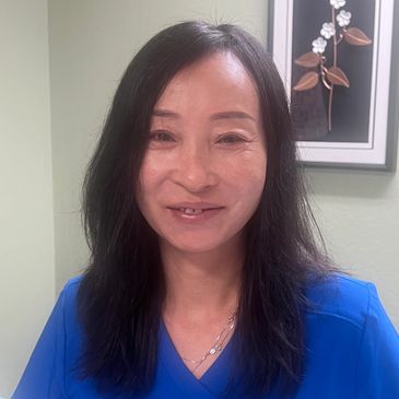 Smiling woman with long dark hair in a blue top.