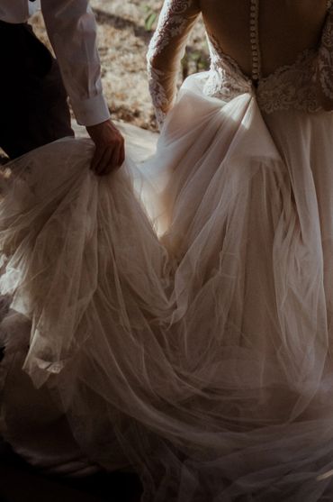 Groom holding the dress of the bride during elopement wedding, image by Wouter Kleynhans