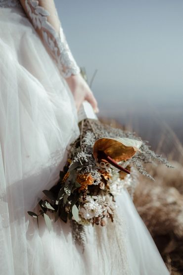 Bride holding flowers by her side during elopement at Intiem Wedding, image by Wouter Kleynhans