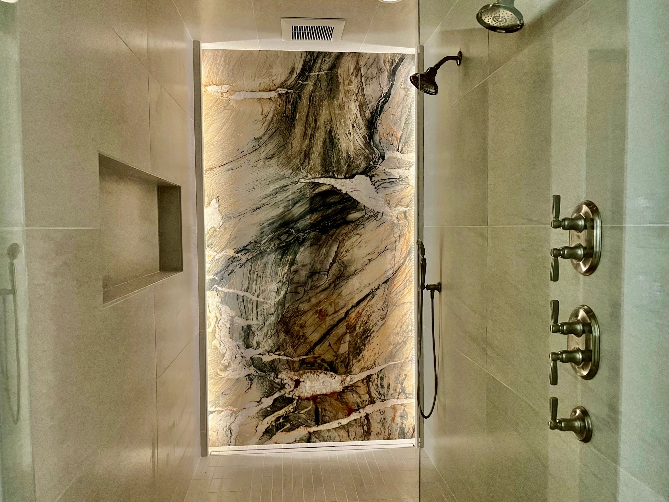 Motion sensor LED lighting frames the beautiful slab of quartzite featured on the back wall of the s