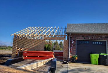 Roof trusses set on a garage addition tied into an existing brick home