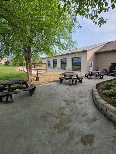 Concrete patio with picnic tables beside a commercial building