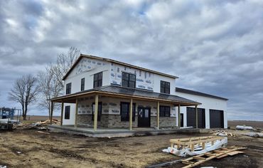 Two-story farmhouse framed and wrapped with porch columns going up