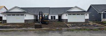 White duplex condos with stone accents and double garages