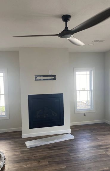 White fireplace surround with mantel between two windows