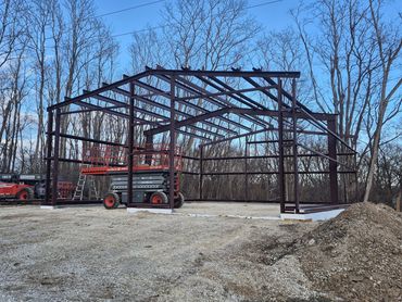 Red-iron steel building frame standing on a new slab