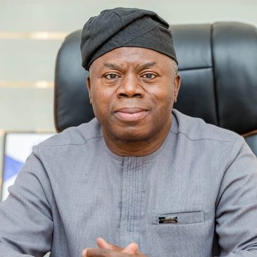 Chief Alhassan Andani is shown in a color photograph wearing a black hat and gray outfit.