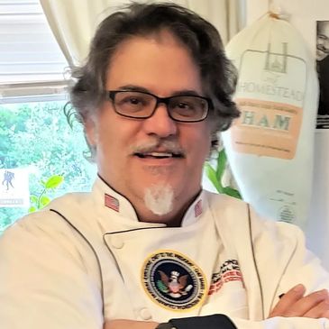 Former White House Chef Marti Mongiello poses in a white chef's coat.