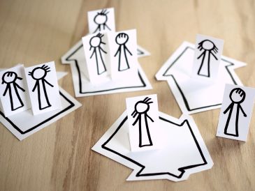 Personnages en papier sur des flèches dessinées.